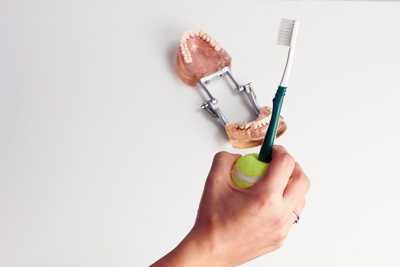 Abb. 2 Verdickter Zahnbürstengriff mit einem Tennisball zum besseren Handling der weichen Handzahnbürste.