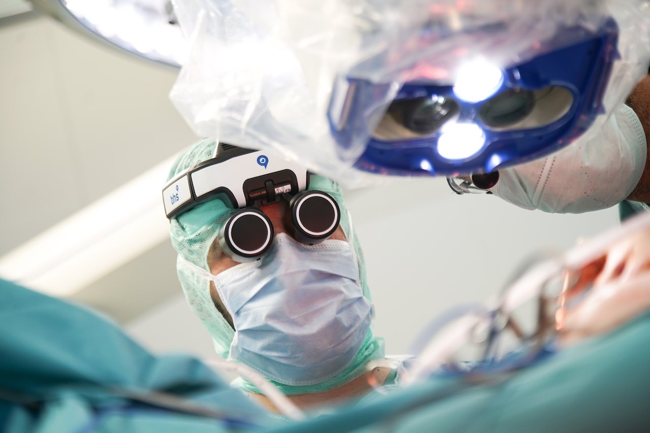 Der Chirurg mit dem Head-Mounted-Display des RoboticScope.
