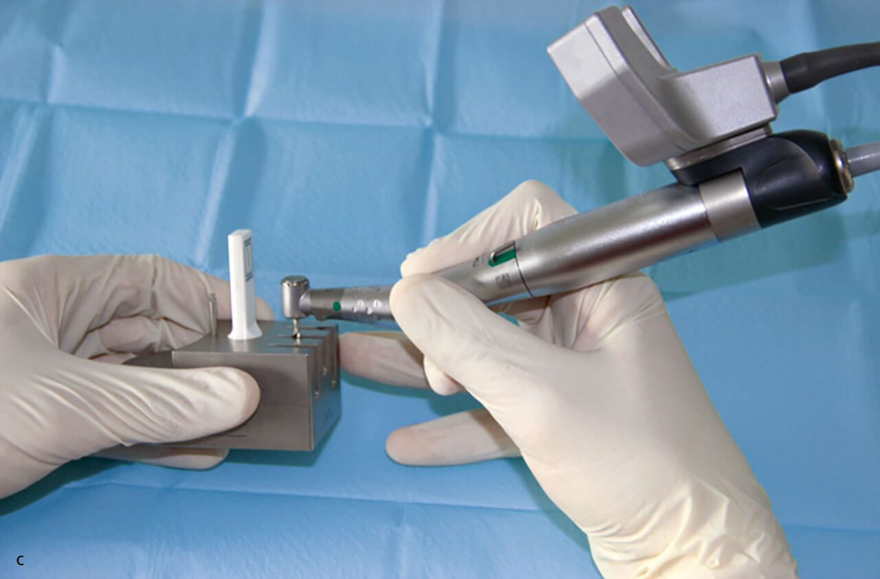 Abb. 1 c Registrierung des Implantatbohrers mit einem Registrierungsinstrument; das optische System (DENAOPT) ist am chirurgischen Winkelstück angebracht.