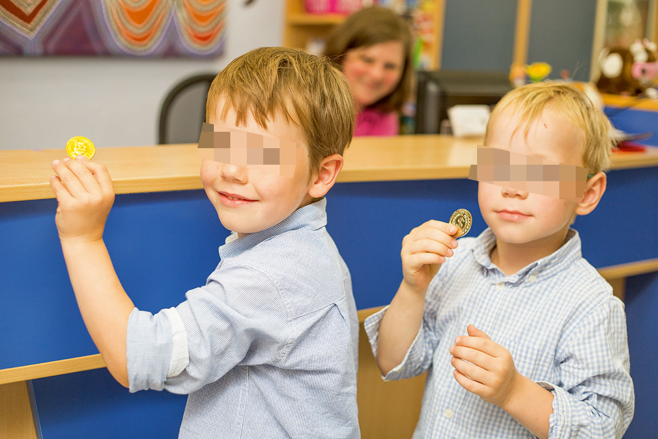 Abb. 5a Nach Abschluss der Behandlung erhält das Kind noch im Behandlungszimmer vom Zahnarzt oder von der Assistenz eine Münze und darf sich an der Rezeption ein Geschenk aus der Spielzeugkiste aussuchen