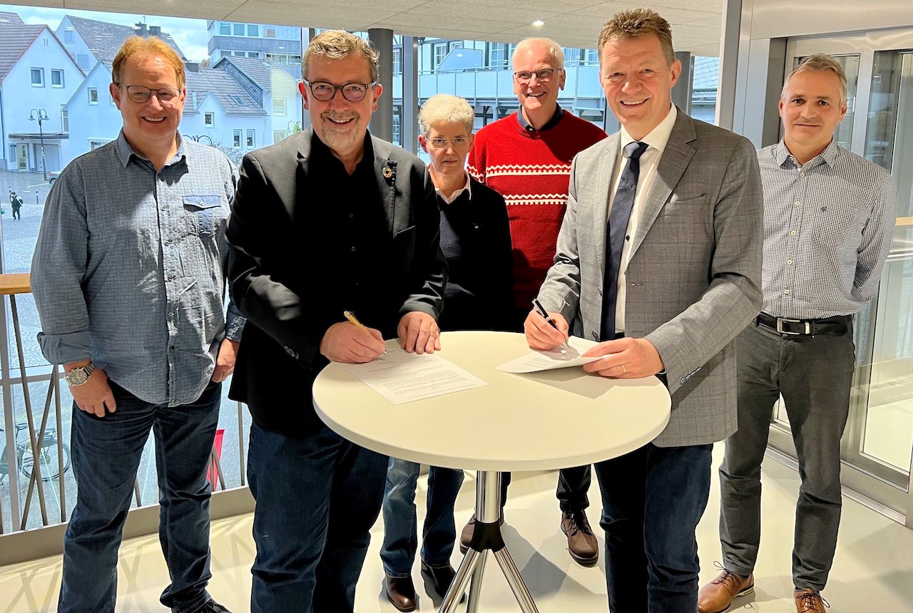 Bürgermeister Bernd Fuhrmann (links) und der Vorstandsvorsitzende der KZVWL, Dr. Holger Seib (rechts), unterzeichneten im Beisein von Zahnärztinnen und -ärzten aus der „Stadt der Dörfer“ gemeinsam den Letter of Intent.